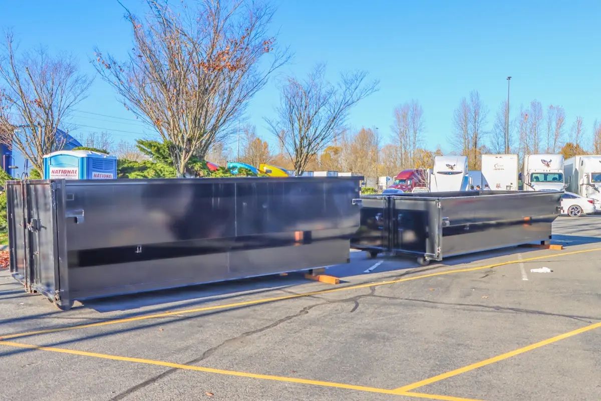 Professional dumpster rental service with roll-off container on residential driveway in Akron